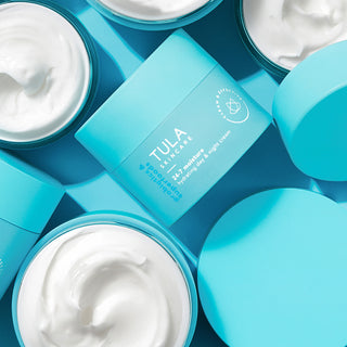 Tula skincare products with blue containers and white cream on a blue background