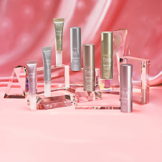 Collection of Tula skincare products on a pink background