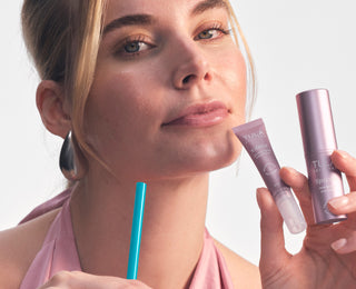 Model holding pink 'Glaze plumping lip treatment and pink 'Spresso energizing eye balm