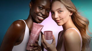 Two women holding Tula products against a gradient background