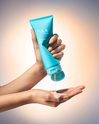 Hand holding a blue Tula product with a blurred background