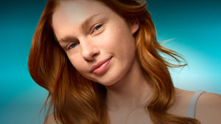 Woman with red hair against a blue gradient background