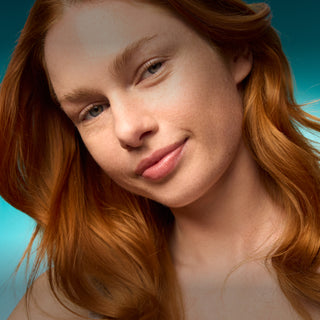 Close-up of a person with red hair against a blue gradient background