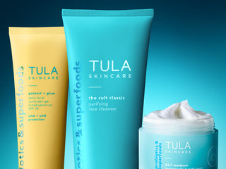 Tula Skincare products including a tube, cleanser, and cream on a gradient blue background