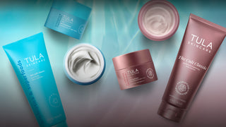 A flat-lay arrangement of Tula Skincare products on a soft teal gradient background.