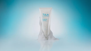 TULA Rich Rinse Cleanser with foam on component on blue background.