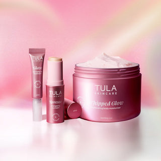 Tula skincare products including a jar and tubes on a soft pink and purple gradient background