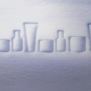 Snow-covered bottles arranged in a row on a snowy surface