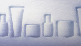 Snow-covered bottles arranged in a row on a snowy surface