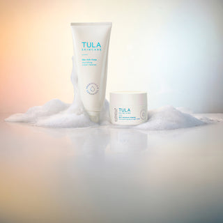 Tula skincare products on a textured surface with a gradient background