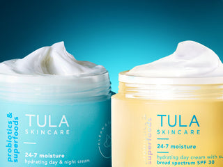 Two jars of Tula Skincare cream on a blue background