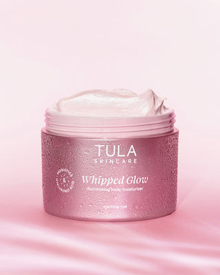 Tula Skincare Whipped Glow moisturizer jar on a pink background