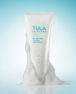 Tula Skincare cream cleanser with foam on a light blue background