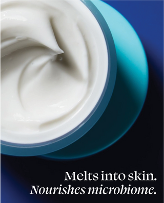 Close-up of a jar of cream with a blue background and text about skin nourishment.