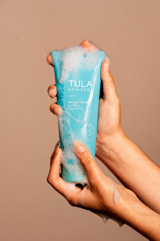 Hands holding a sudsy cult classic cleanser