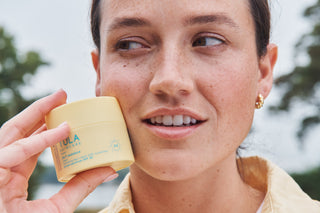 TULA Skincare 24-7 SPF moisture held by a model looking away